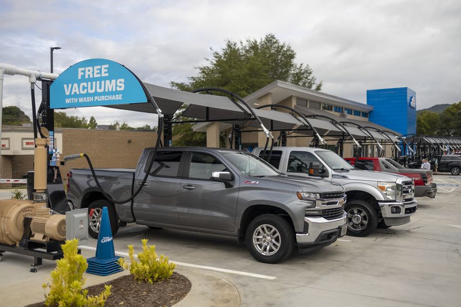 Cars parked at Mr. Clean vacuum bays beneath a canopy reading Free Vacuums with wash purchase