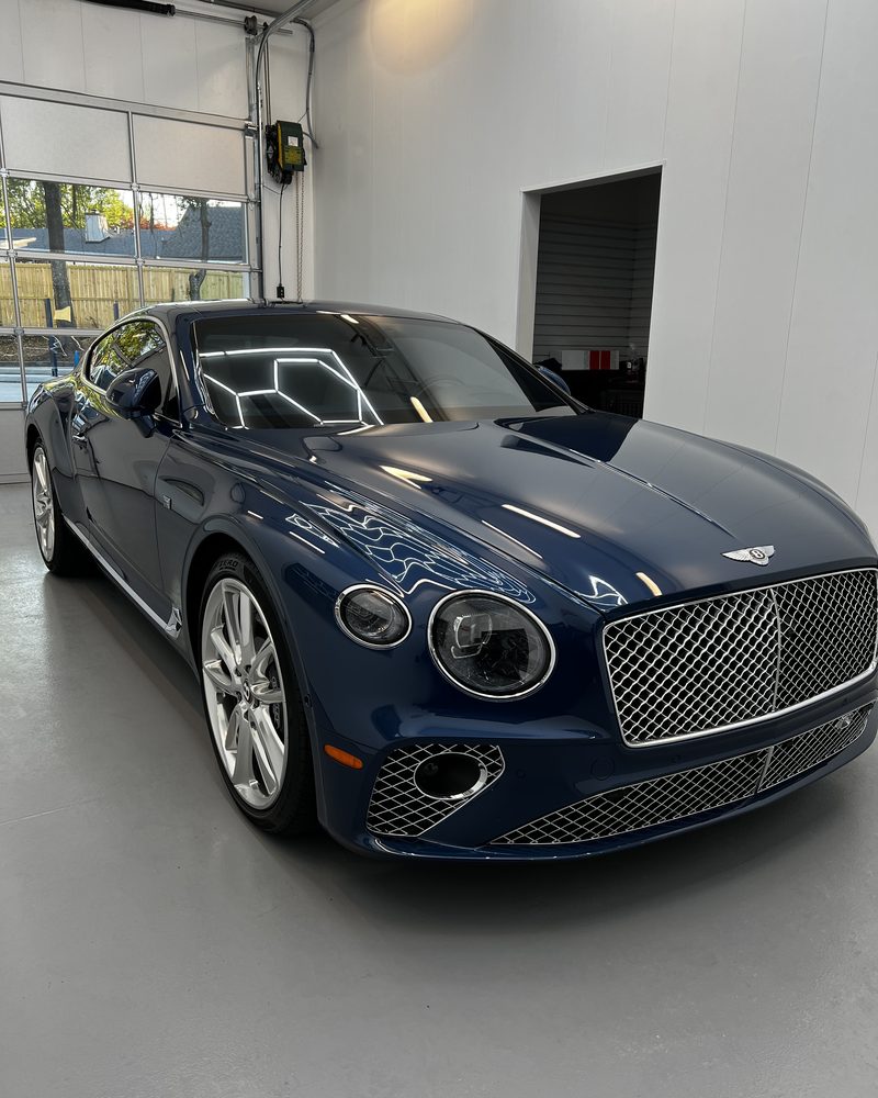 A dark blue Bentley Continental GT with a deep, even gloss after coating