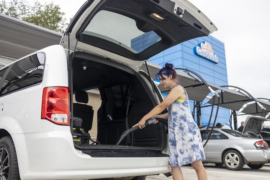 A customer vacuuming the back of their van at a free Mr. Clean vacuum station