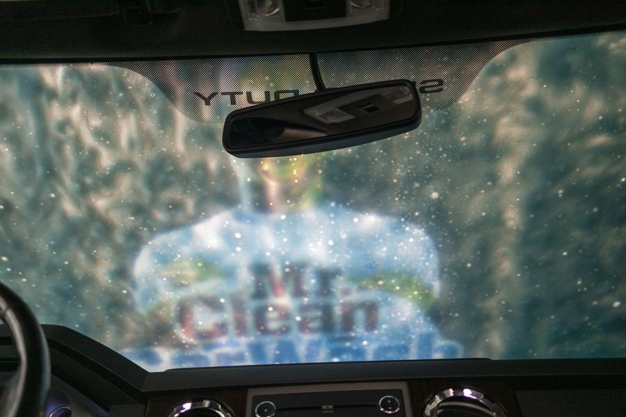 Foam sheeting off a windshield, seen from the driver's seat inside the wash
